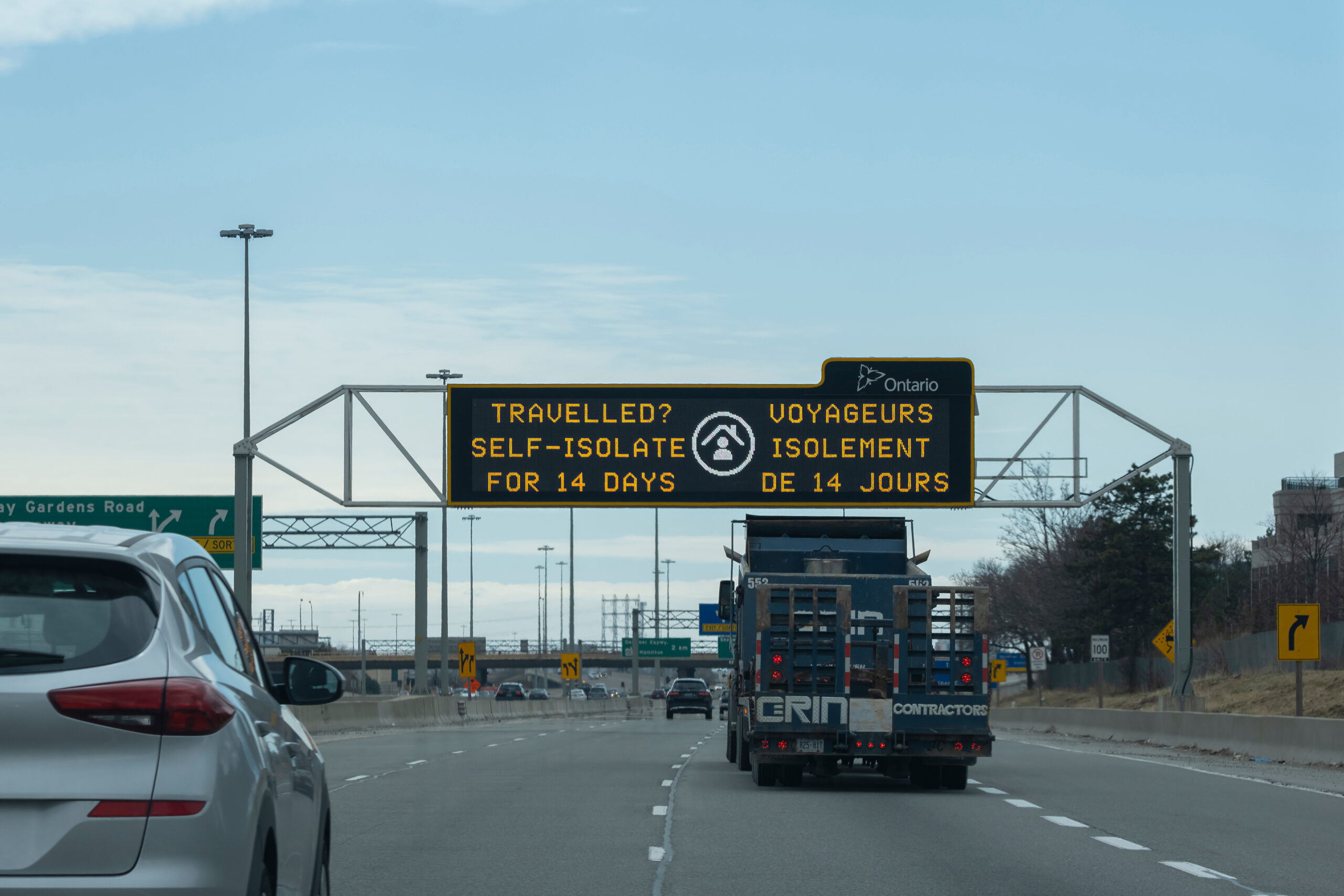 Toronto, Ontario, Canada - Mar 4, 2020: Sign Travelled? Self isolate for 14 days on a scoreboard over highway during corona virus pandemic outbreak. Selective focus.