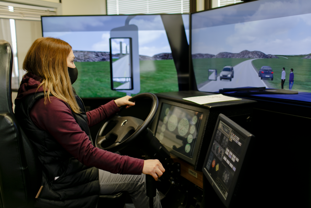woman wearing mask in truck driving simulator